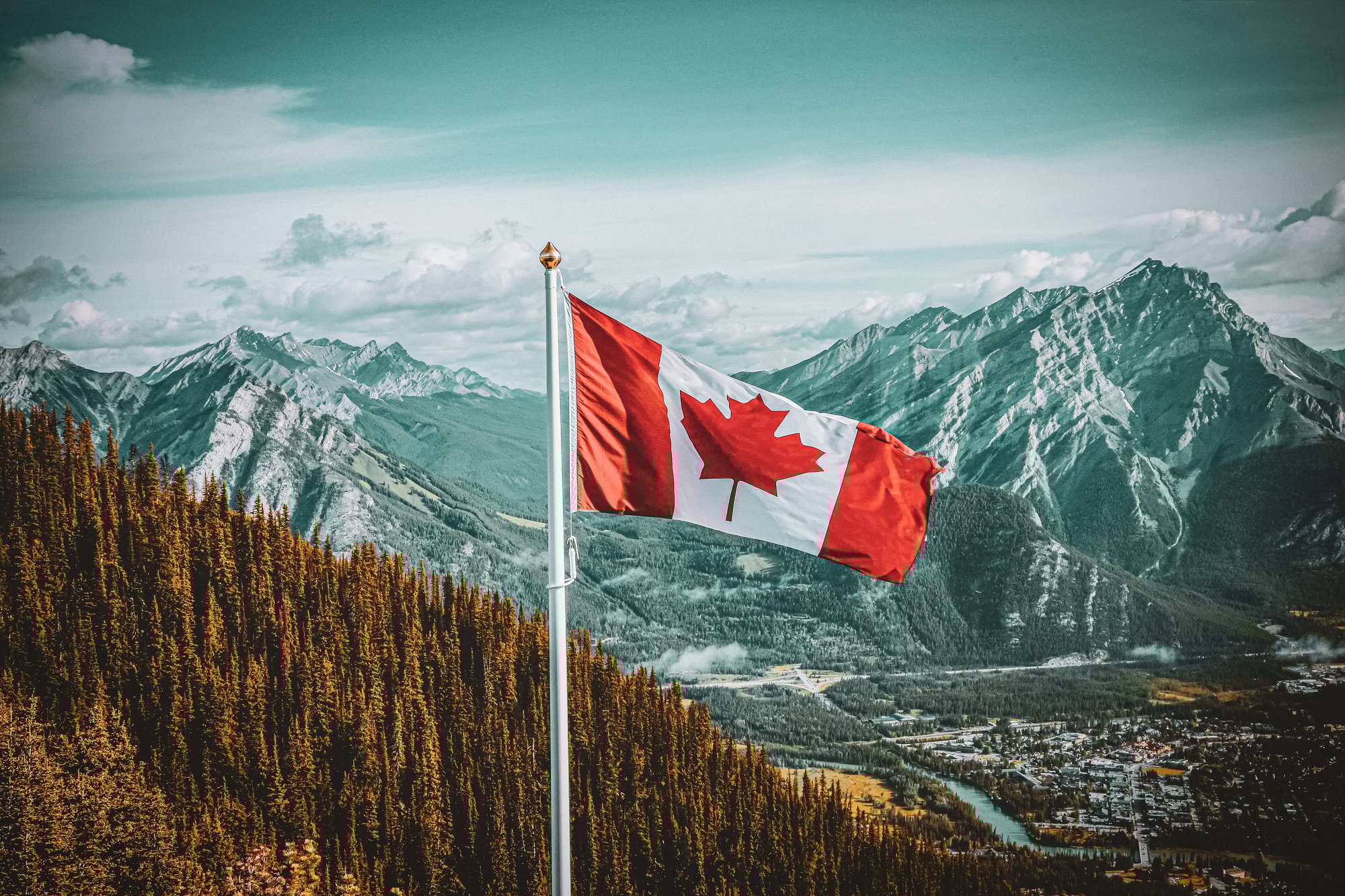 Canadian flag flying against a backdrop of scenic mountains
