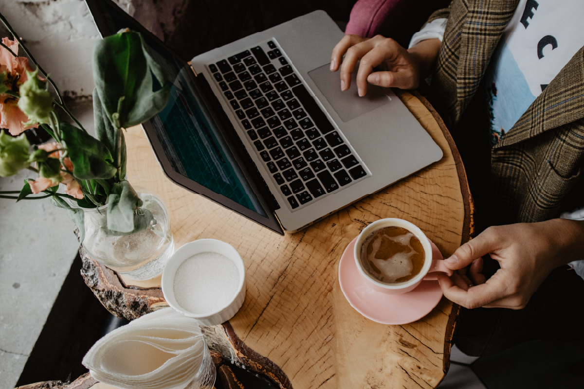 Having coffee and working on a laptop